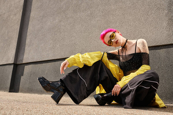 full length, pink haired girl in yellow sunglasses and trendy outfit posing and looking at camera