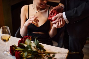 cropped man gifting red heart-shaped box to african american girlfriend on Valentine`s day clipart