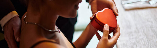 banner of man gifting heart-shaped box to happy african american girlfriend on Valentines day
