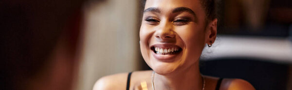 happy african american woman smiling sincerely during date on Valentines day, romantic dinner banner