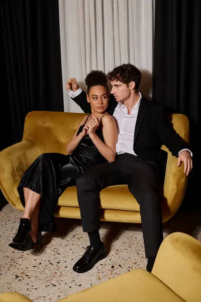 ビロードソファに座ってエレガントなスーツで黒いドレスとハンサムな男の美しいアフリカ系アメリカ人女性 — ストック写真