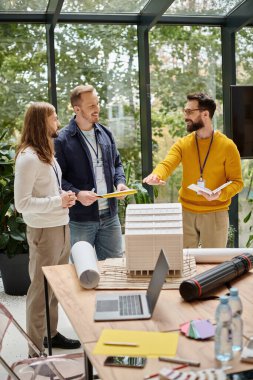 Gündelik giysiler içindeki neşeli ve yakışıklı mimarlar yeni başladıkları ve birlikte çalıştıkları konsept üzerinde birlikte çalışıyorlar.