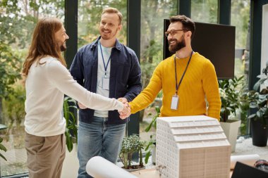 cheerful handsome architects in casual outfits working together on their startup, coworking concept clipart