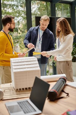 İyi görünümlü iş arkadaşları günlük kıyafetlerini giyer ve işteyken birlikte çalışırlar.