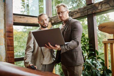 focused good looking business leaders in fashionable clothes posing together while working hard clipart