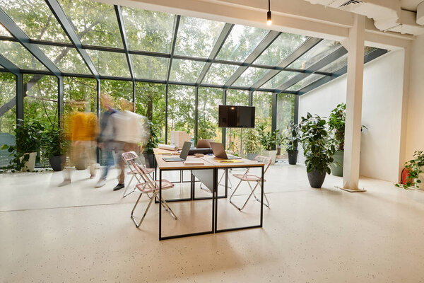 Долгосрочное фото коллег в размытом движении, идущих в своем офисе во время работы над стартапом