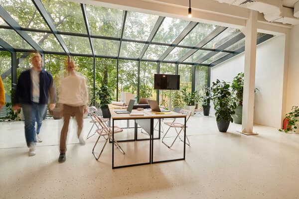 Долгосрочное фото коллег, позирующих в размытом движении в офисе во время работы над проектом