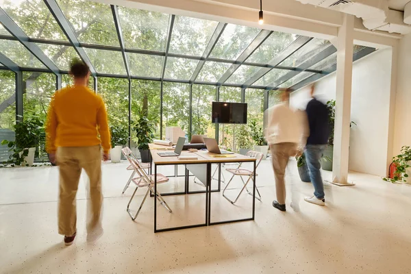 stock image long exposure photo of businessmen in blurred motion walking in office while working on startup