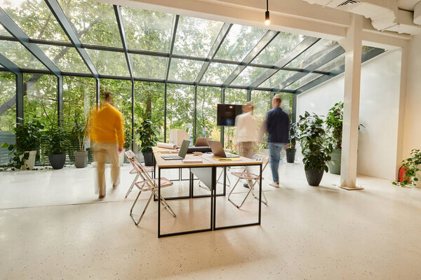 Долгосрочное фото сотрудников в размытом движении, идущих в своем офисе во время работы над стартапом