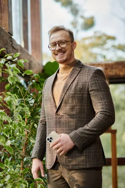 cheerful handsome man with glasses in sophisticated jacket smiling happily and looking at camera