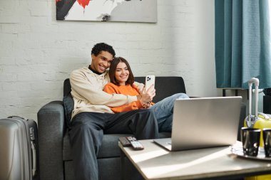 Bir çift, yurt odasındaki selfie için gülümseyen aşk ve teknoloji anlarını yakalar.
