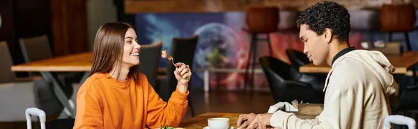 stock image diverse couple sharing a joyful moment over a healthy meal in a trendy cafe, banner