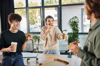 Neşeli adamlar arkadaşça ve rahat bir atmosferde pizzanın tadını çıkarıyorlar. Yeni başlayanlar öğle yemeği molası veriyorlar.