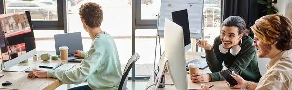 Yapım ekibinin afişi ofiste cihazların yanında proje tartışması, 20 'li yaşlarda gülümseyen adamlar.