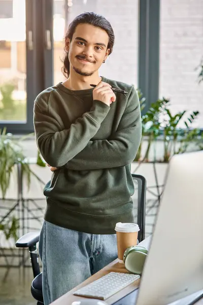 stock image Relaxed professional standing with stylus pen and smiling in post-production workspace, man in 20s