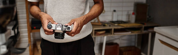 cropped banner of african american photographer expertly handling a vintage camera in photo lab
