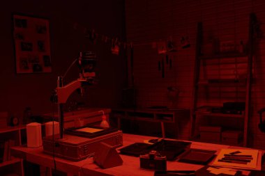 darkroom interior with red light, showcasing the process of film development and photography art clipart