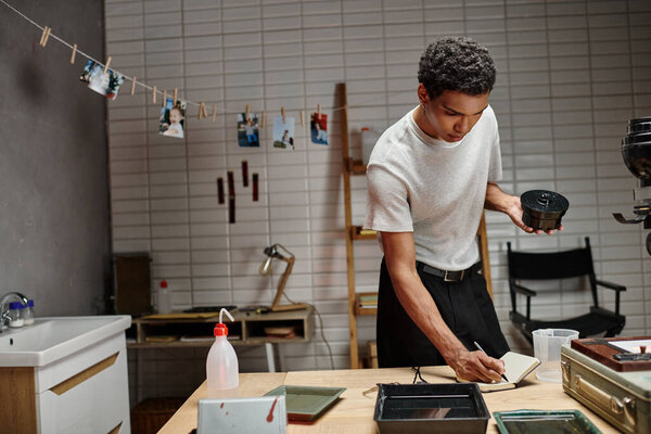 аналоговый фильм развития, африканский американец делает записи в то время как тщательный процесс времени