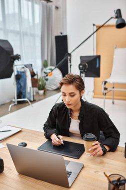Günlük giysiler içinde nefes kesici profesyonel tasarımcı çizim tabletiyle stüdyoda çalışıyor.