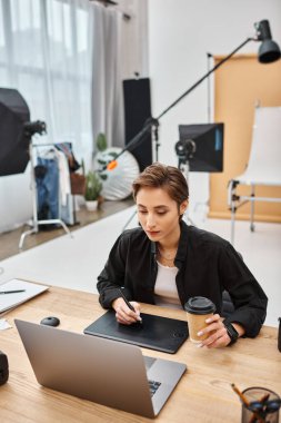 stunning professional female designer in casual attire working with her drawing tablet in studio clipart