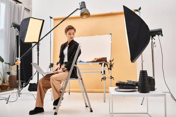 stock image charming short haired photographer sitting and retouching photos in her studio using her laptop