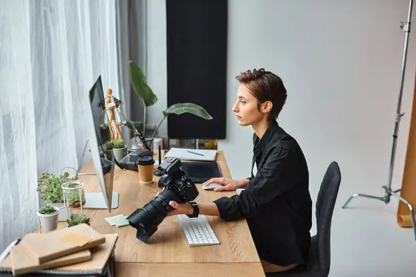 stock image attractive professional female photographer in casual attire working hard on her photos in studio