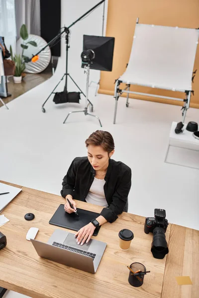 穿着休闲装的迷人的职业女性设计师在工作室里与她的绘图平板电脑一起工作 — 图库照片