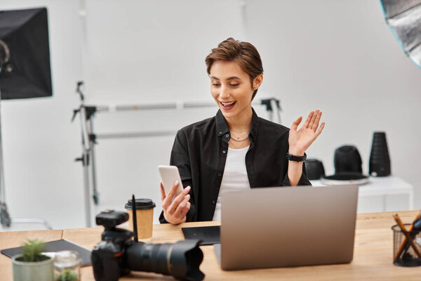 веселая фотограф в повседневной одежде делает истории для своих социальных медиа в своей студии