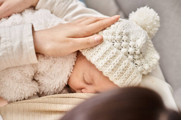 cropped view of loving mother holding her newborn child and breastfeeding him, modern parenting