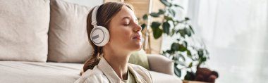 carefree teenage girl in her wireless headphones listening music and holding cup of tea, banner clipart