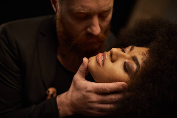 bearded man seducing pretty african american woman with curly hair, intimate moment of sexy couple