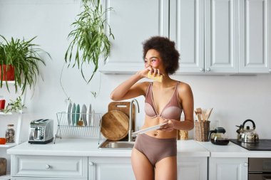 african american woman in lingerie with pink patches under eyes washing plate with sponge, laugh clipart