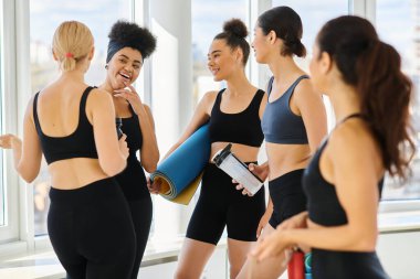 Aktif görevde olan beş neşeli ve genç kadın pilates stüdyosunda çalıştıktan sonra sohbet ediyorlar.