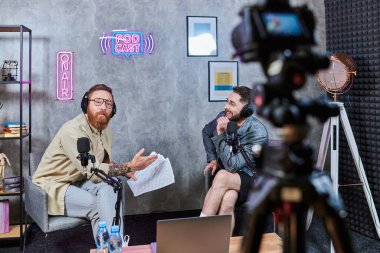 Güzel görünümlü, şık bir röportajcı podcast sırasında genç konuğuyla konuşuyor.