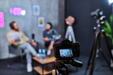 Kulaklıklı, sakallı, soru soran, afiş veren şık, bulanık adamlar çekmeye odaklan.