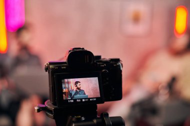 Kameraya odaklan, sakallı, kulaklıklı bulanık adam podcast 'te soruları tartışıyor.