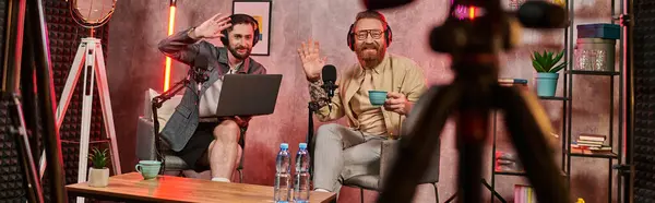 stock image handsome men with headphones drinking coffee and talking during podcast, waving hands, banner