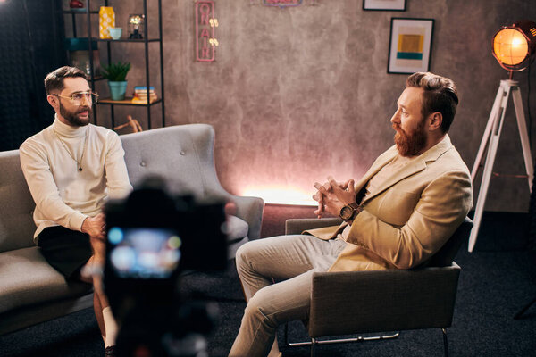two handsome bearded men in elegant stylish attires sitting and discussing interview questions