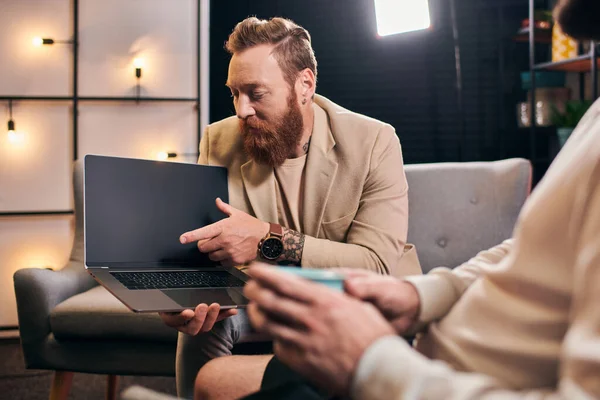 stock image good looking trendy men in elegant attires with coffee and laptop discussing interview questions