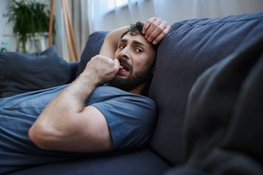 Bunalımlı umutsuz bir adam rahat bir evde koltukta uzanıyor ruhsal çöküntü ve psikoterapi sırasında.