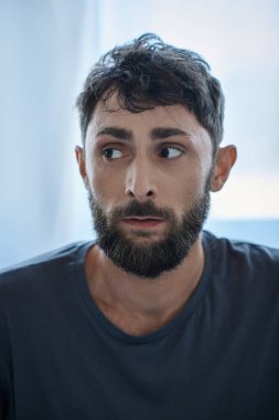 Tişörtlü endişeli adam depresif bölümde acı çekiyor, zihinsel sağlık farkındalığı