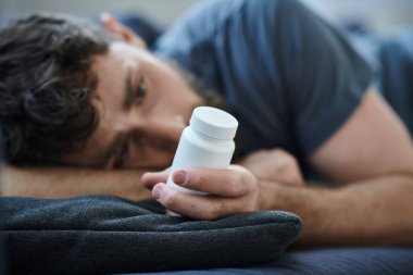 Depresyon sırasında kendine zarar veren haplar alan çaresiz bir adam, zihinsel sağlık farkındalığı