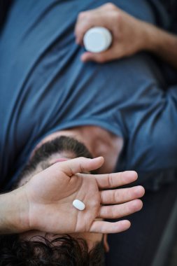 Depresyonda olan sakallı hasta adam depresyon sırasında hap alıyor, zihinsel sağlık farkındalığı