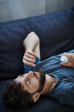 Depresyonda olan sakallı hasta adam depresyon sırasında hap alıyor, zihinsel sağlık farkındalığı