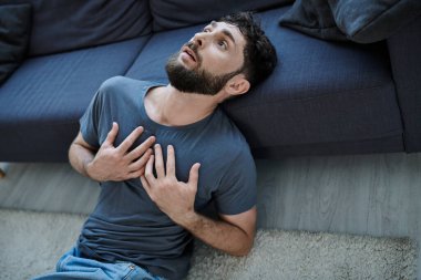 ill traumatized man with beard in home wear having severe panic attack, mental health awareness clipart