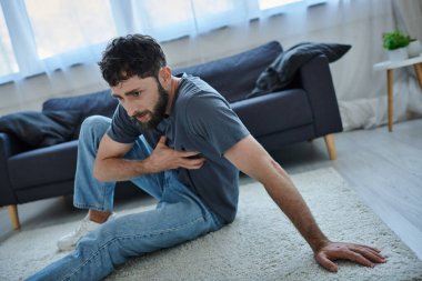 depressed traumatized man with beard in homewear having severe panic attack, mental health awareness clipart
