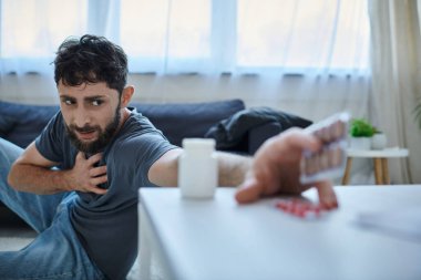 Depresyon geçiren endişeli sakallı adama odaklanın. Bulanık haplarına, akıl sağlığına ulaşın.