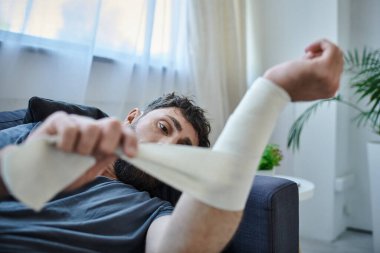 traumatized man with bandage on arm after attempting suicide lying on sofa, mental health awareness clipart