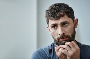 Tişörtlü sinirli bir adam sinir krizi, ruh sağlığı ve kan kaybından ölene kadar dudaklarını ısırıyor.