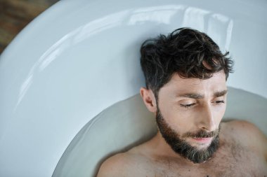depressed frustrated man with beard lying in bathtub during breakdown, mental health awareness clipart